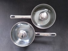Two small metal saucepans with lids. Used but functional for camping etc