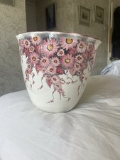 white ceramic hanging vase adorned with a pink cherry blossom design.