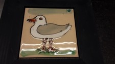 Seagull-shaped ceramic tile in a wooden hanging frame.