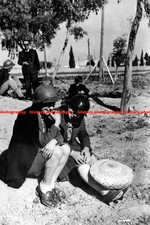 F018404 Woman shelters with French steel helmets after a bomb alert WW2