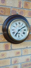 Antique small round Wallclock. Hardwood  frame  and  brass bezel. Working Order 
