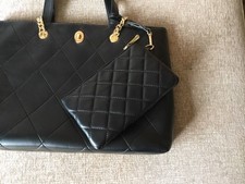 Black Faux Leather Handbag With Chain Shoulder Handles and attached purse.