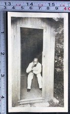Man Sitting on Toilet Outhouse