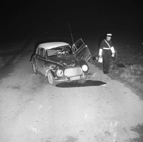 Policeman beside car damaged - beside,
