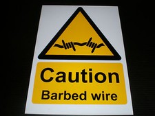 CAUTION BARBED WIRE sign or