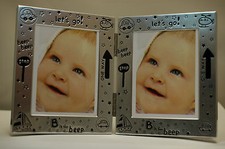 POLISHED ALLOY - DOUBLE HINGED - PHOTO FRAME - BABY MOTIF TO BORDER 