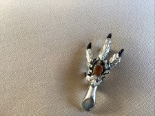 A SILVERTONE SCOTTISH GROUSE FOOT WITH STAG AND ORANGE CENTRE STONE BROOCH 