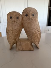 Pair of hand carved wooden owls perching on branch single piece of wood