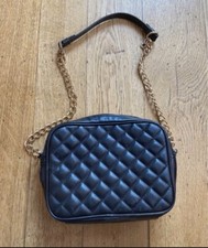 Jaegar classic black leather handbag over shoulder.