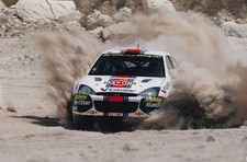 FORD ESCORT, IN RALLY ACTION THROWING UP DUST, COLOR DIGITAL PHOTOGRAPH.