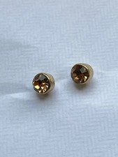 Dainty gold coloured stud earrings with a yellow diamante stone