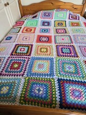 Large blanket made of multi coloured granny Squares.