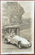 RPPC YOUNG BOY SAT IN FANCY TOY CAR BLUEBIRD TYPE STUDIO SETTING BLACKPOOL BEACH