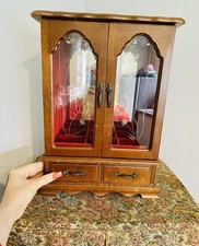 vintage wooden jewelry armoire with etched glass doors and a red velvet interior
