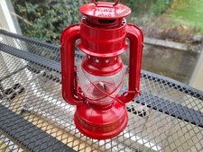 Small red storm or hurricane lantern possibly unused.