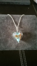 Glass heart with blue background and gold glitter on silver chair