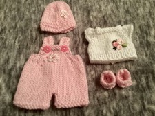 Hand knitted dolls clothes to
