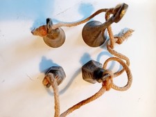 Set of four brass bells on woven, two inscribed INDIA internally, 2 are hexagol