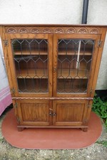 JAYCEE CARVED OAK BOOKCASE, 2 LEADED DOORS, ADJUSTABLE SHELVES, CUPBOARD BASE.