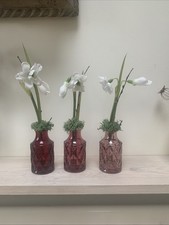 Three small pink bud vases with snowdrops and moss