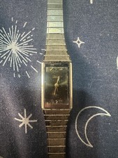 vintage gold-tone quartz wristwatch with a black rectangular dial