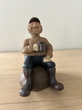 Vintage Fisherman Sitting on a Rock Holding a Mug