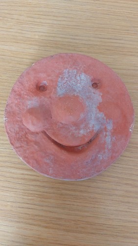 Terracotta wall plaque smiling
