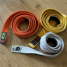 Three White Yellow And Orange Jujitsu Martial Arts Belts