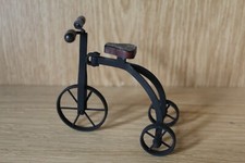 Vintage model metal tricycle with wooden seat and handlebar grips.