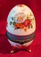 Pretty little porcelain egg trinket box, floral decoration on three feet.