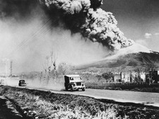 Army jeep speeds along a road