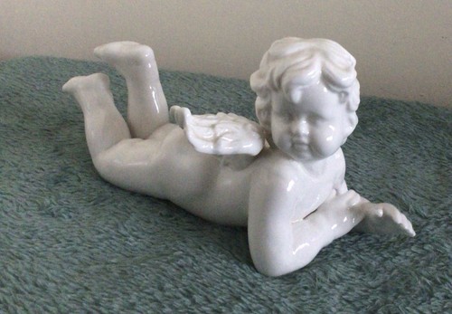 Ceramic laying down cherub - down,