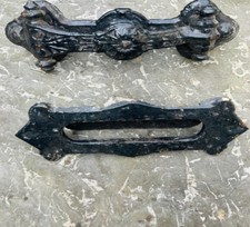 An antique cast iron door knocker and letter box