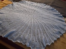 A new hand crochet baby circular shawl made in blue 4ply yarn