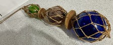 GRADUATED COLOURED GLASS FISHING FLOATS IN KNOTTED ROPE NET SEASIDE BEACH HUT