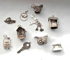 variety of vintage silver charms: symbols of love, keys, prams, wishing well