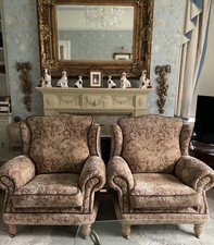 A PAIR OF WINGED ARMCHAIRS . (POSSIBLY PARKER KNOLL ). AUTUMNAL COLOURS . 