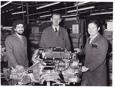 LOTUS ENGINE (TURBO), WITH WORKERS IN FACTORY, PHOTOGRAPH.