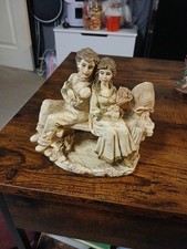 Vintage Young Couple Ivory In Colour Sitting On Bench