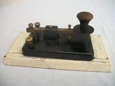 Morse key with bakelite base on wood block