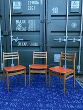 Set of three Danish teak dining chairs with orange vinyl seats
