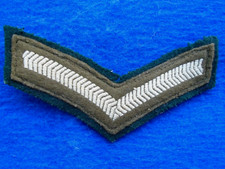 BRITISH MILITARY LANCE CORPORALS STRIPE, CHEVRON ON DARK GREEN BACKING