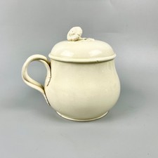 A Leeds Pottery covered cream pot with floral knop and foliate terminals c1814