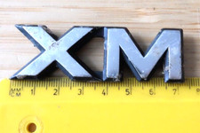 XM  CAPITAL LETTERS CAR BADGE. Possibly for KIA SORENTO or CITROEN.  Any idea?