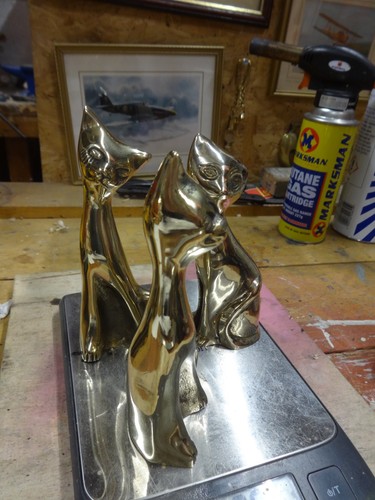 Three brass cats - three, sitting.