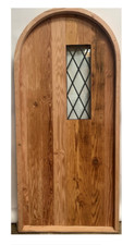 Rustic reclaimed lumber arch top door solid wood storybook iron glass grids pane