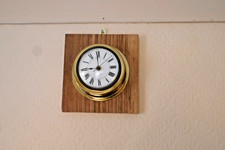 Brass wall clock on wooden