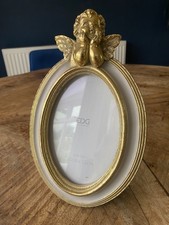 White & Gold Vintage Oval Picture Frame fits 10cm x 15cm photo. Cherub on top.