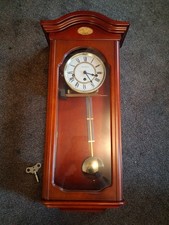 Wall clock with pendulum in wooden case by London Clock Co, mechanical wind up 