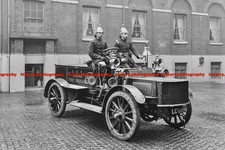 F001879 Firemen in brass helmets aboard a motor hose tender London Fire Brigade